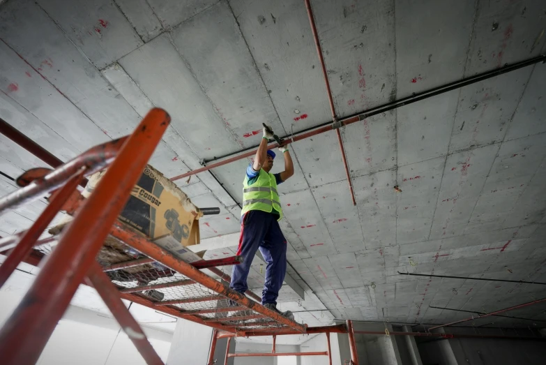 the person is fixing some pipe work in the air