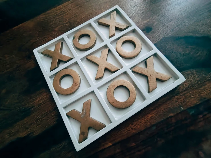 letter x and number x spelled in brown icing on a wooden table