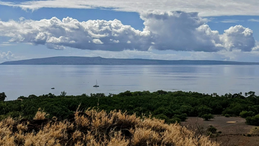 an island is pictured on the far side of the ocean