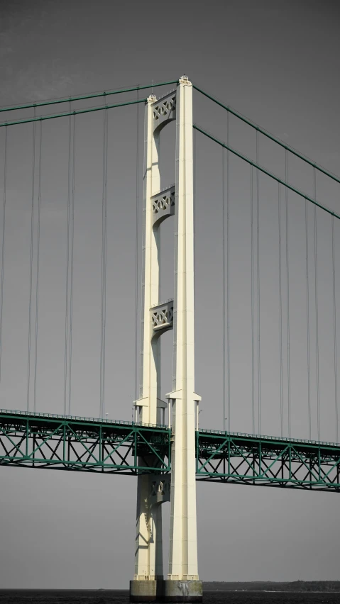 a tall white bridge with several green wires