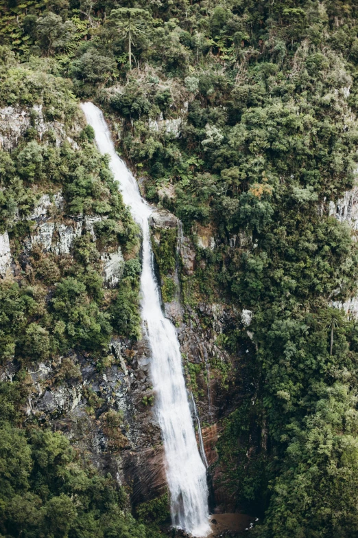 a small waterfall falling down from the side of a rocky cliff