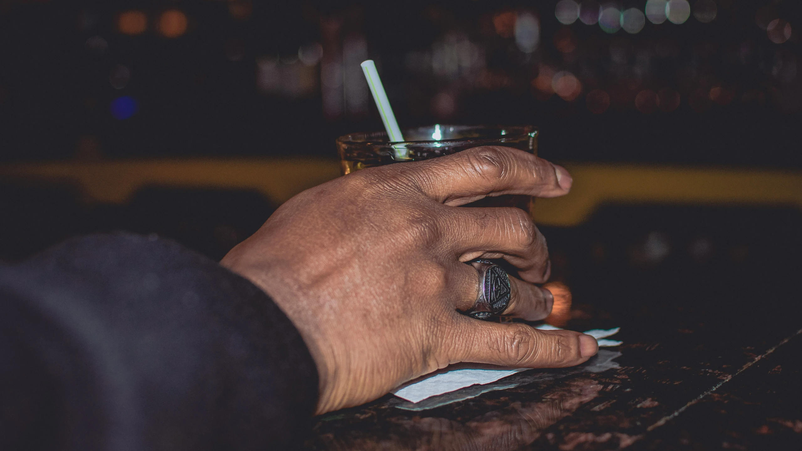 person sitting on a bench with a drink in front of them