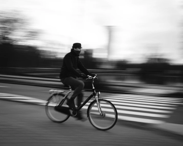 a man riding a bike down a street in front of an intersection