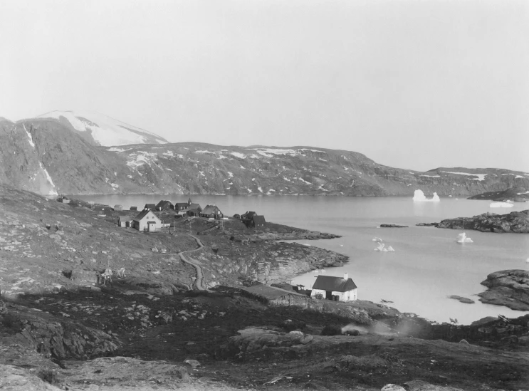 an old picture shows a rocky area with snow on mountains