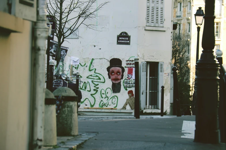 a street with a white and blue graffiti wall