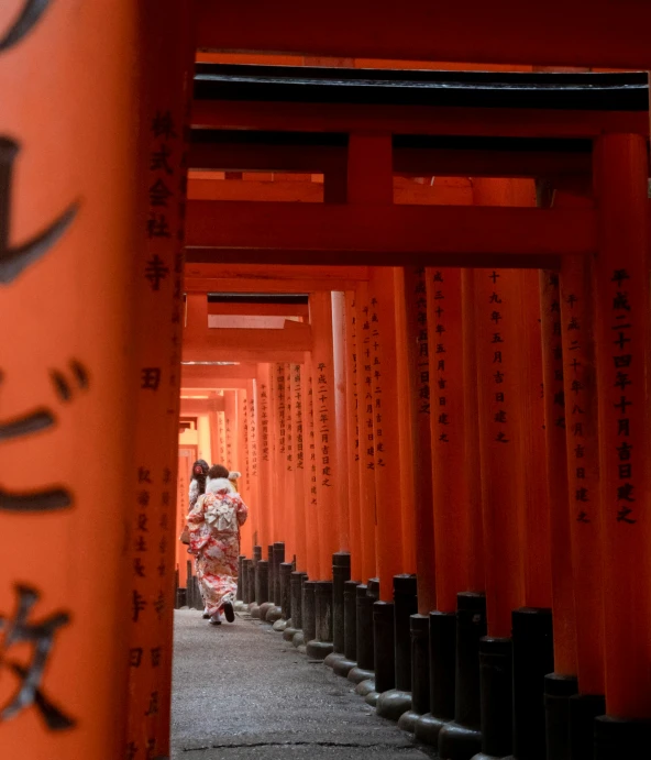 a person in a long line of orange lanterns