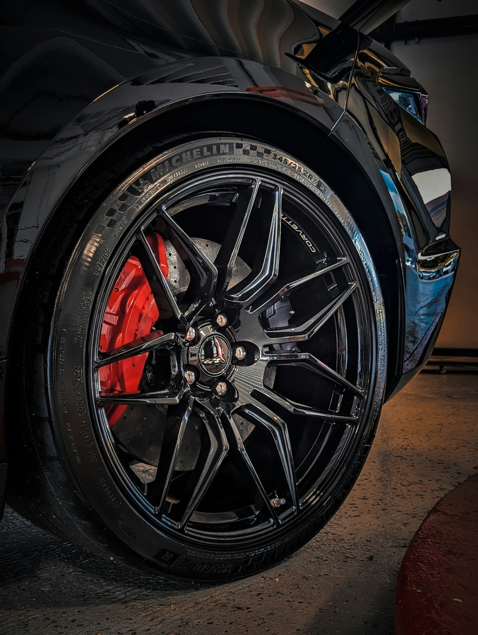 a blue sports car with red rims is seen