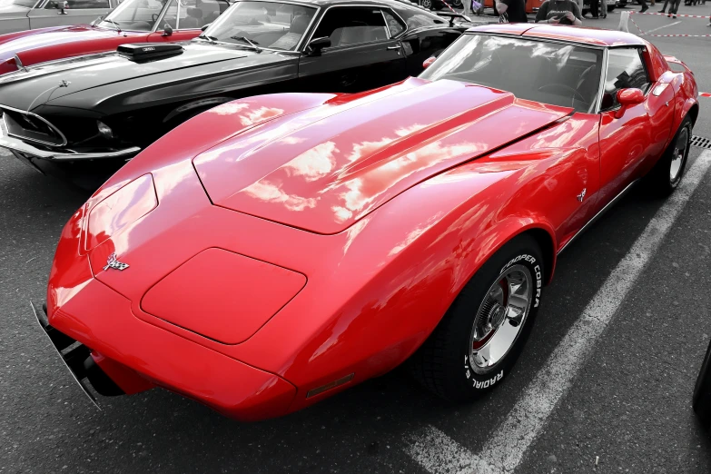 a red corvette corvette sports car with hood down