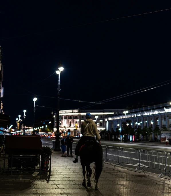 two people riding on horses next to a street