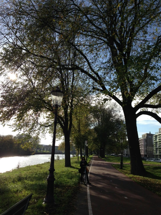 a person on a bike rides down a trail next to a river