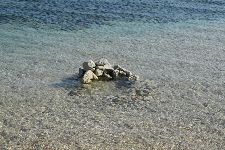 an image of a beach area with rocks and water