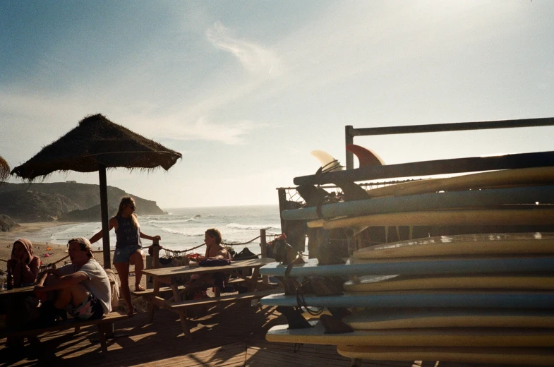 several people standing by a fence on a beach