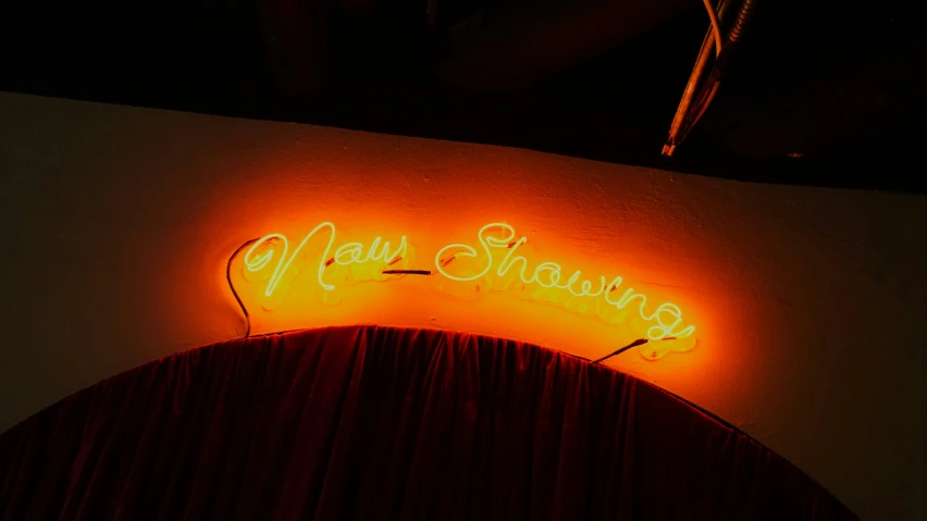 a neon sign with writing that reads new strawberries on it