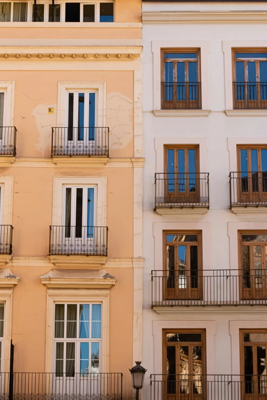 several apartment buildings have balconies with balcony tops