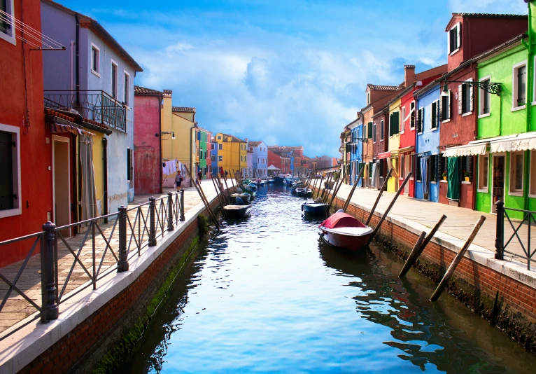 the canal is colorfully painted and has houses on it