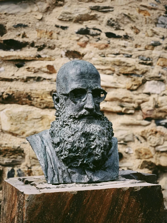 a face statue in front of a stone wall