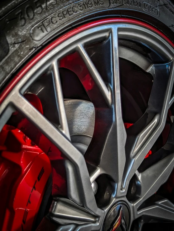 the front wheel of a sports car with red ke pads