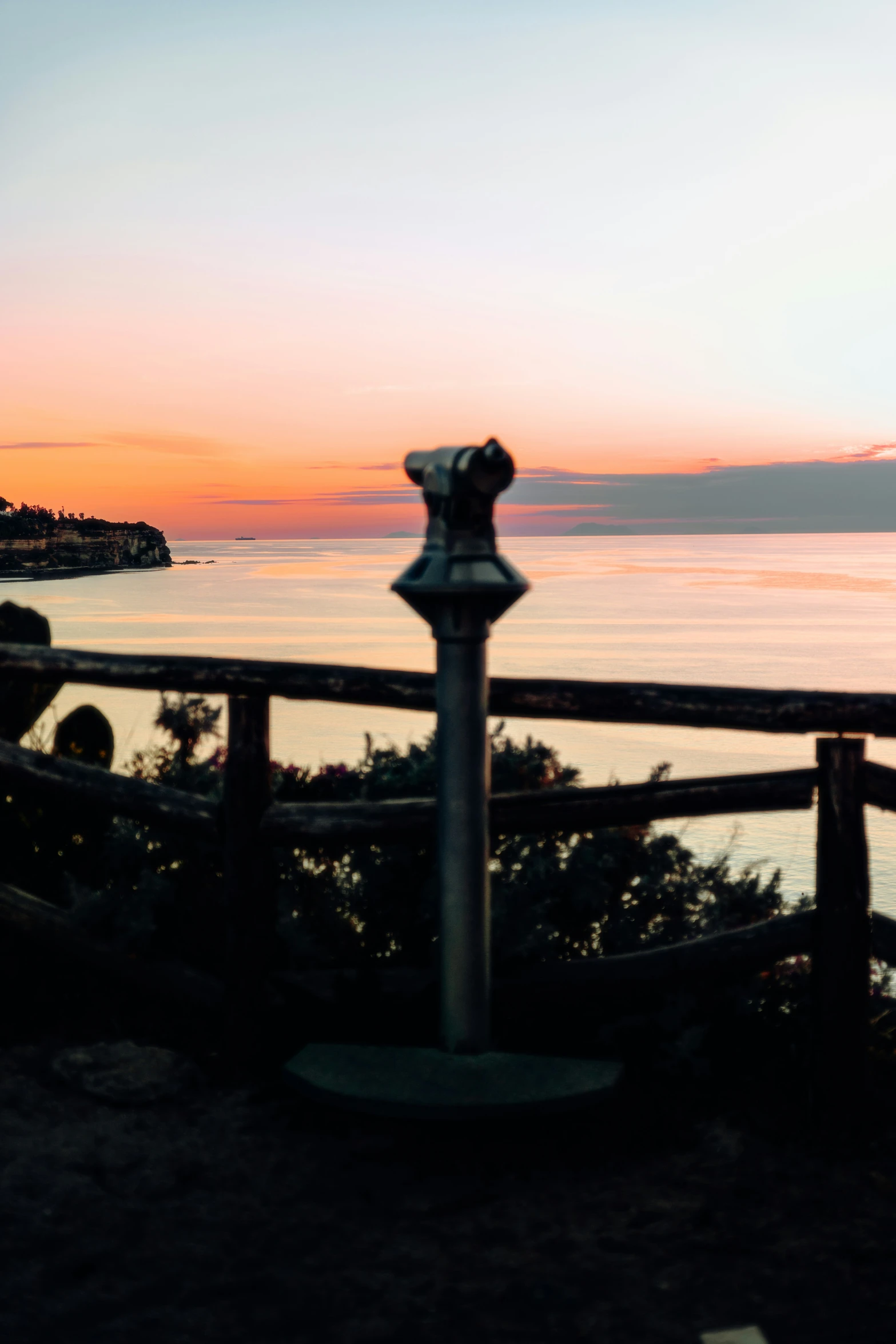 there are two large poles in front of the fence by the water