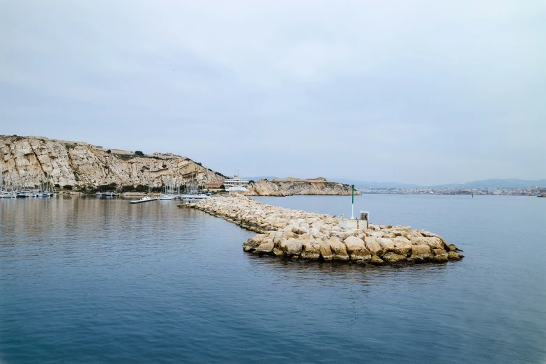 an island in the water with two birds standing on top