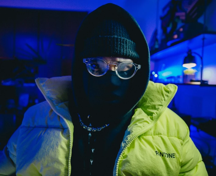 man in neon coat and hoodie standing outside in dark
