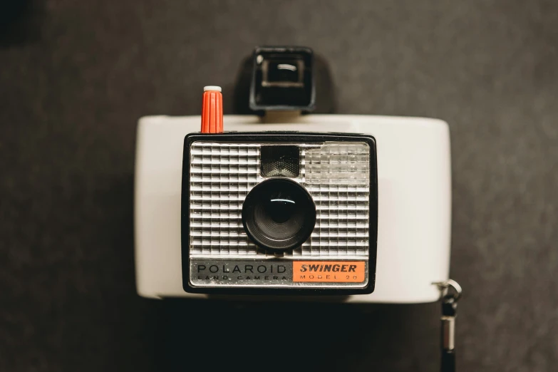 an old white camera with orange and black ons