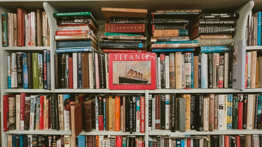 the books are arranged in rows in the book shelf