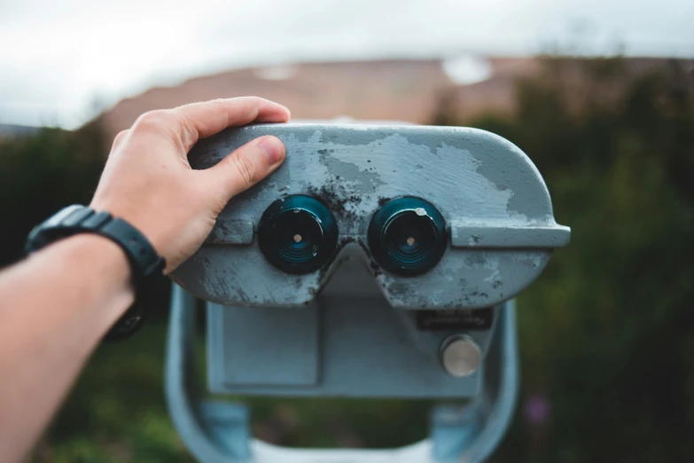 a person using the top of a silver binoculars