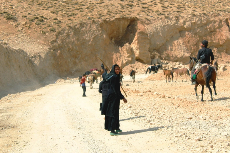 a woman with some horses standing by herself