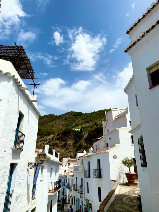 a street has tall white buildings with windows on each side