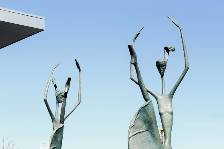 three metal sculptures in front of the sky