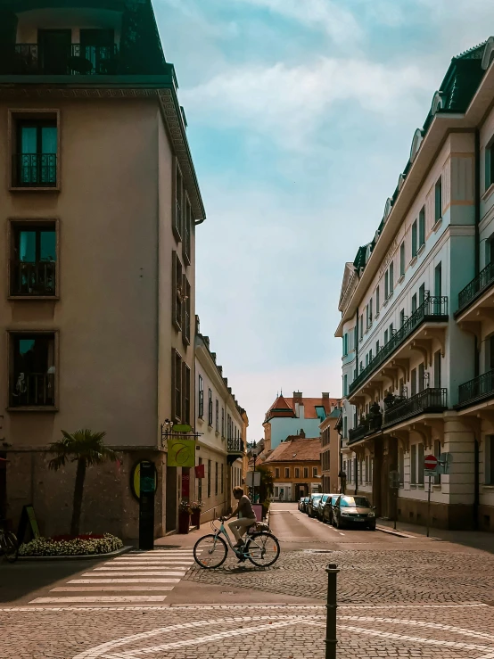 there is a man riding a bike down the street