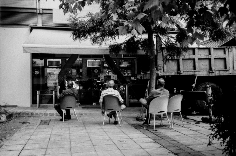 an old black and white po with people in chairs