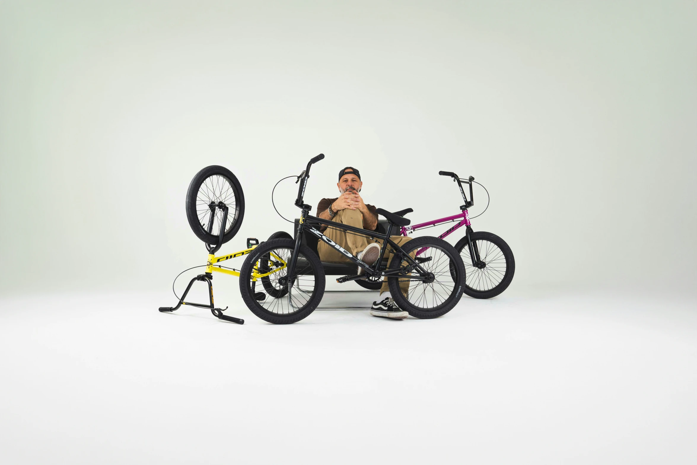 a guy sitting on a bicycle with 3 bikes attached to it