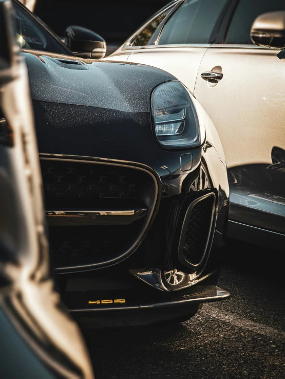 the front end of two cars parked in a lot