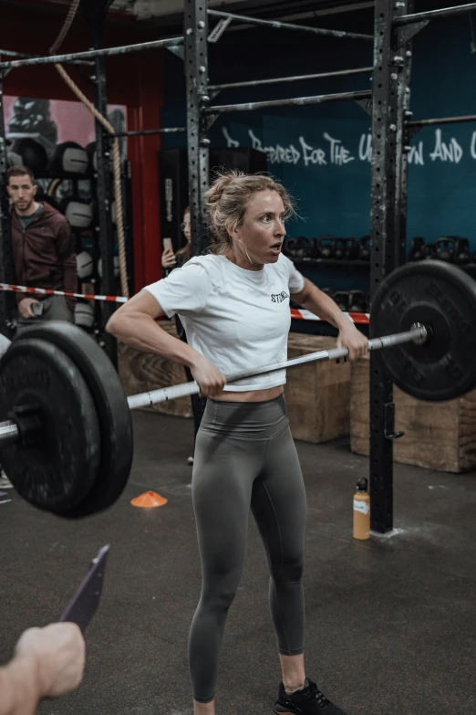a woman doing deadlifts at a gym