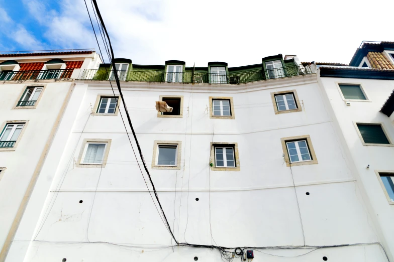 a multi story building with several windows and sky behind it