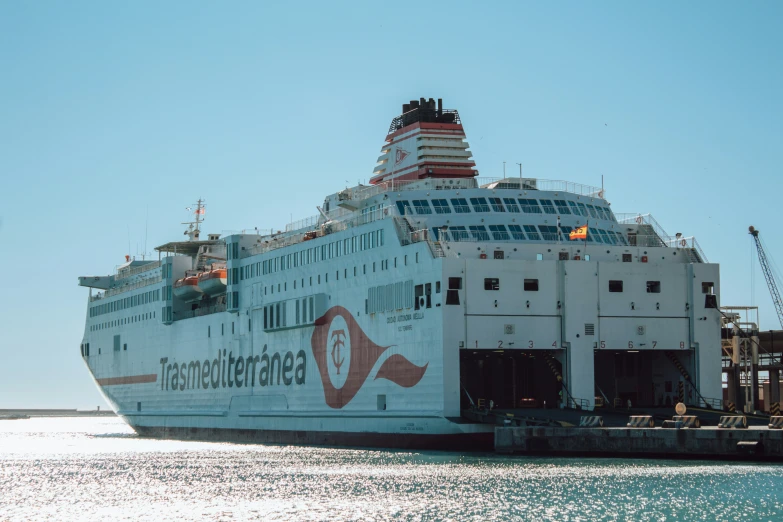 the large white boat is docked at the dock