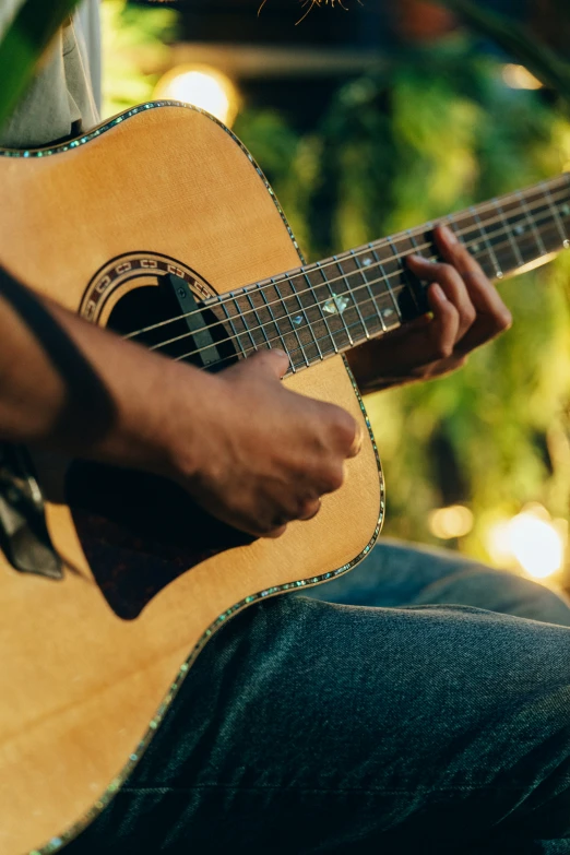 someone playing an acoustic guitar on their lap