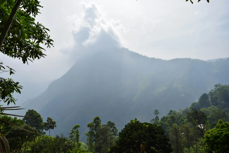 the clouds are covering the top of a mountain