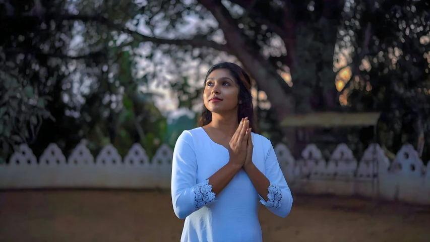 a woman standing in the middle of a yard, clapping