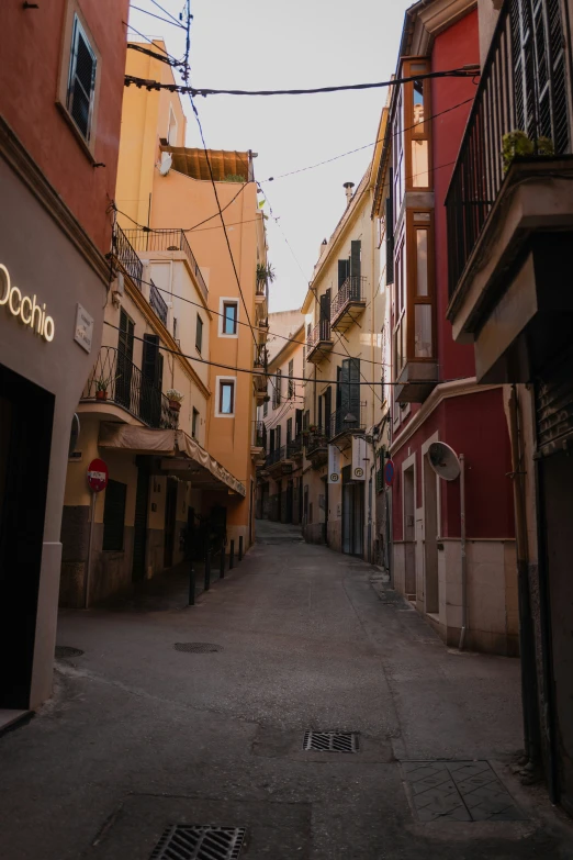 an alley with buildings and a street light hanging overhead