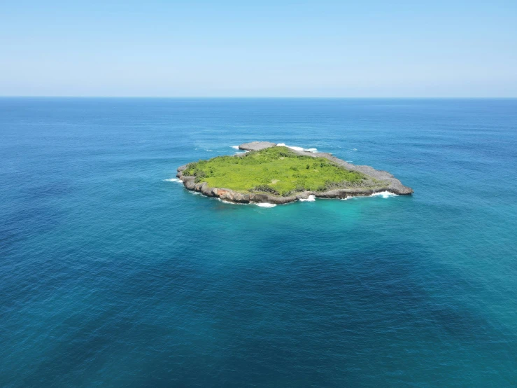 an island sitting in the middle of blue water