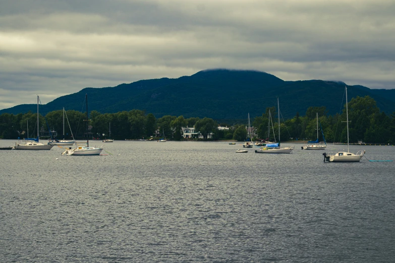 some boats are sailing in the water and some mountains