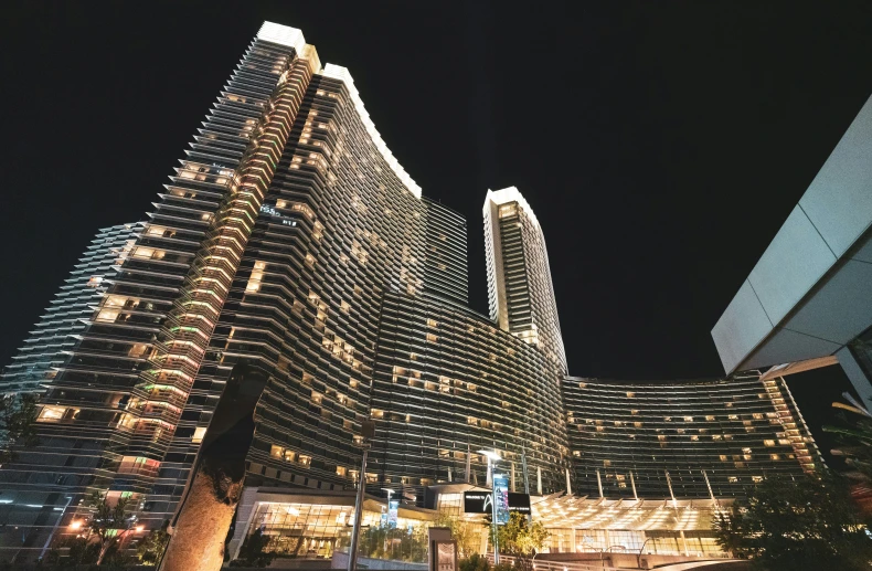 two buildings, one of them lit up at night