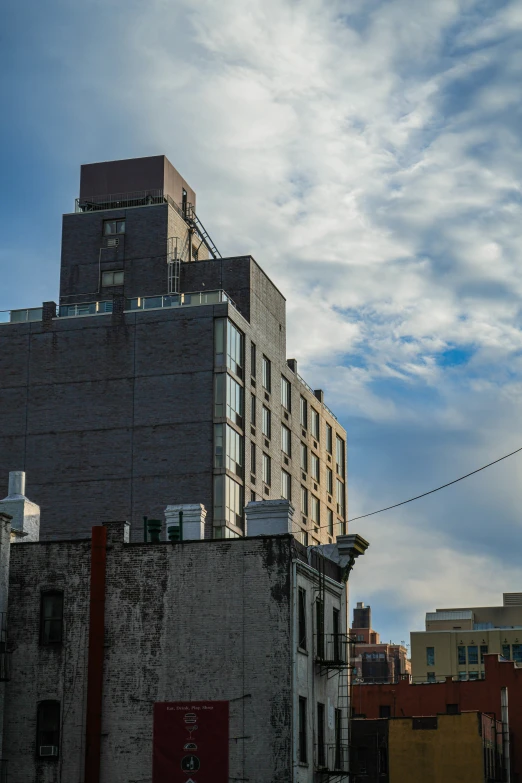 a tall building near buildings with windows and power lines