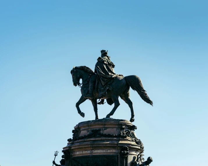 statue of a man on horse mounted on top of a building