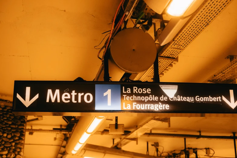 a sign points the way in an underground metro