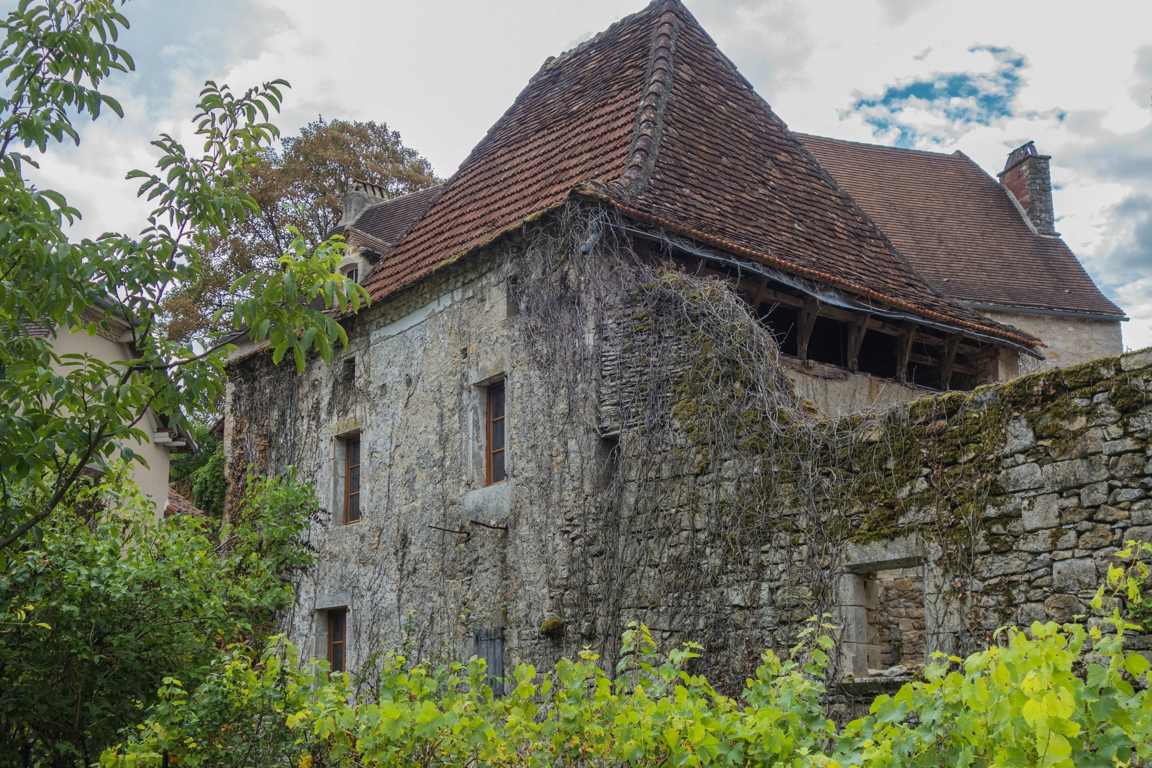 old house with an unusual turreted roof made of concrete and ivy