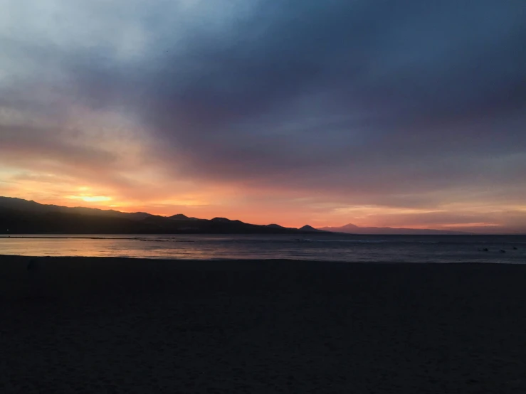 a person standing on a beach looking at the ocean