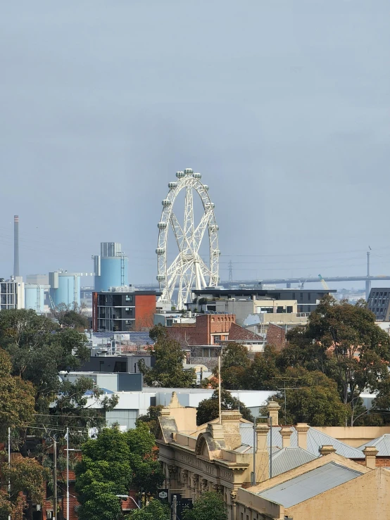 a ferris wheel towering over the skyline of an urban area